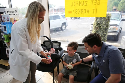 pharmacist gives child flavored liquid medicine